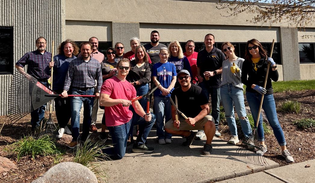 Group photo of LBS employees with gardening tools